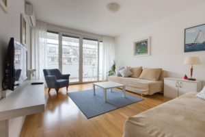 Living room with two sofa beds, entrance to the terrace and big windows.