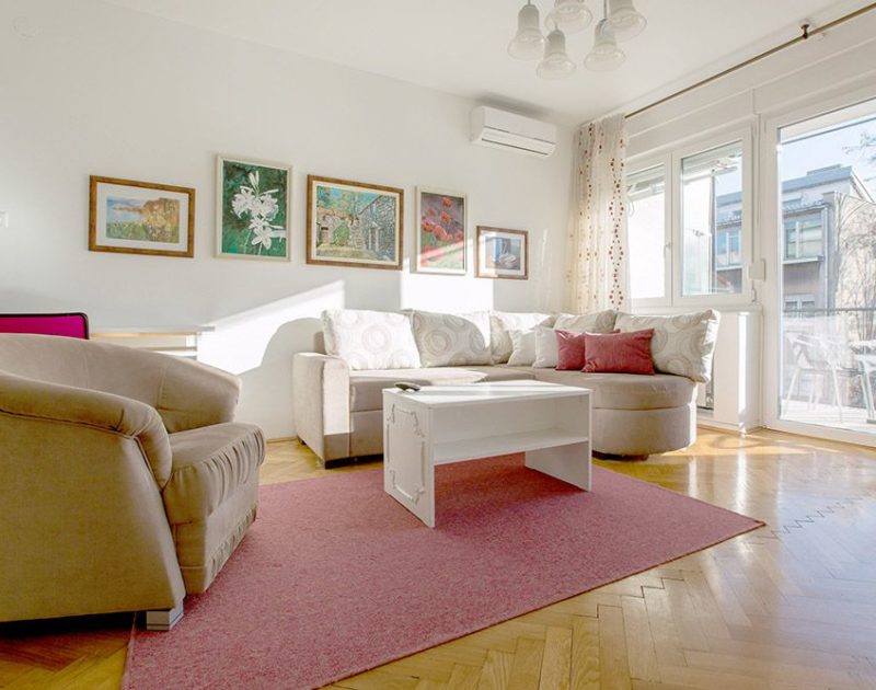 Living room with double sofa bed, armchair and exit to the sunny terrace.