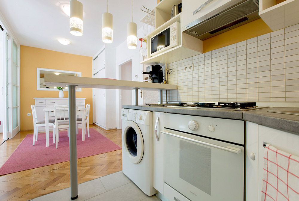 Fully equipped kitchen with washing machine.
