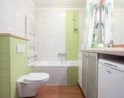 Bathroom with bath tub and shower, toilet, sink and washing machine.