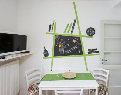 Living room with double bed table and art painting on the wall behind it.